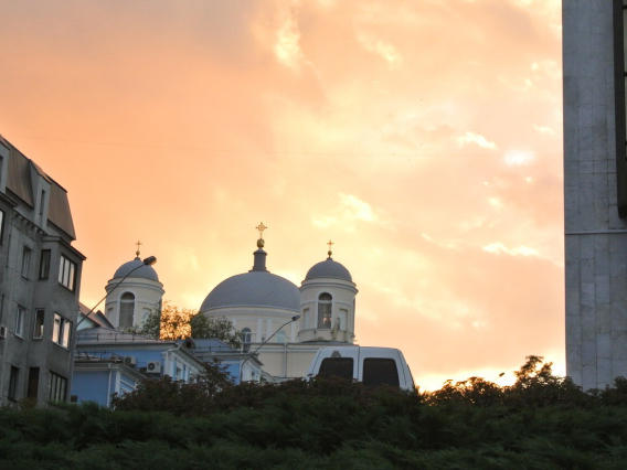 Igreja ortodoxa ao entardecer com céu alaranjado