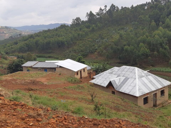 Paisagem rural com dois edifícios de telhado de metal em uma colina arborizada